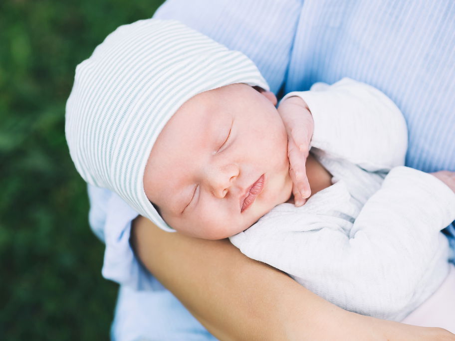 Mutter mit ihrem neugeborenen Baby auf dem Arm.