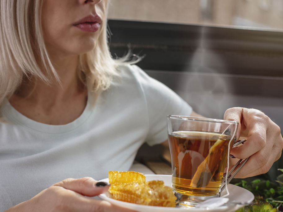 Eine Frau nimmt heißen Pfefferminztee zu sich.