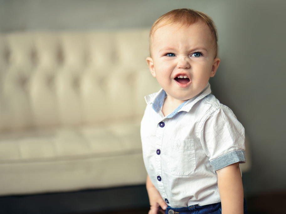 Kleiner Baby-Junge rümpft die Nase und schaut keck in die Gegend.