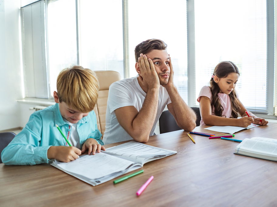 Vater hat keine Lust auf Hausaufgaben mit seinen Kindern.
