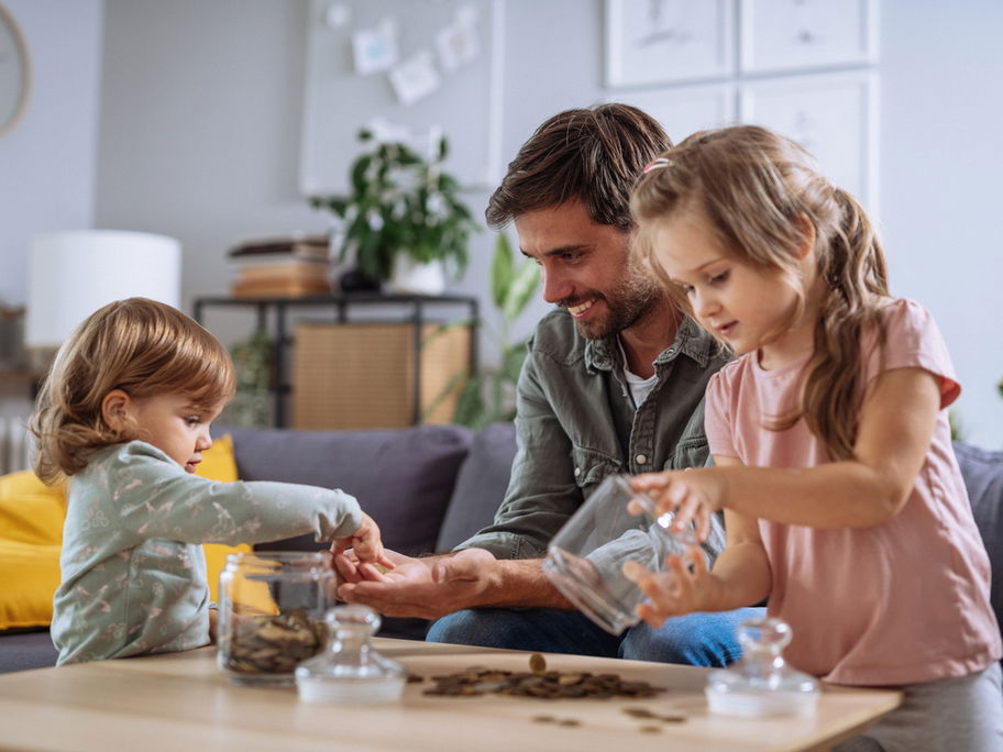 Papa und Kinder zählen Geld.
