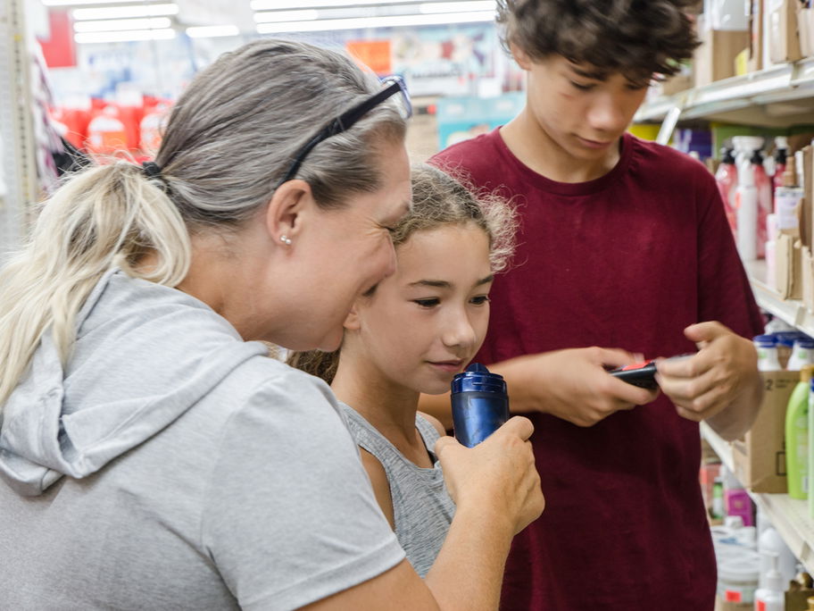 Mutter sucht mit ihren Kindern ein Deo aus.