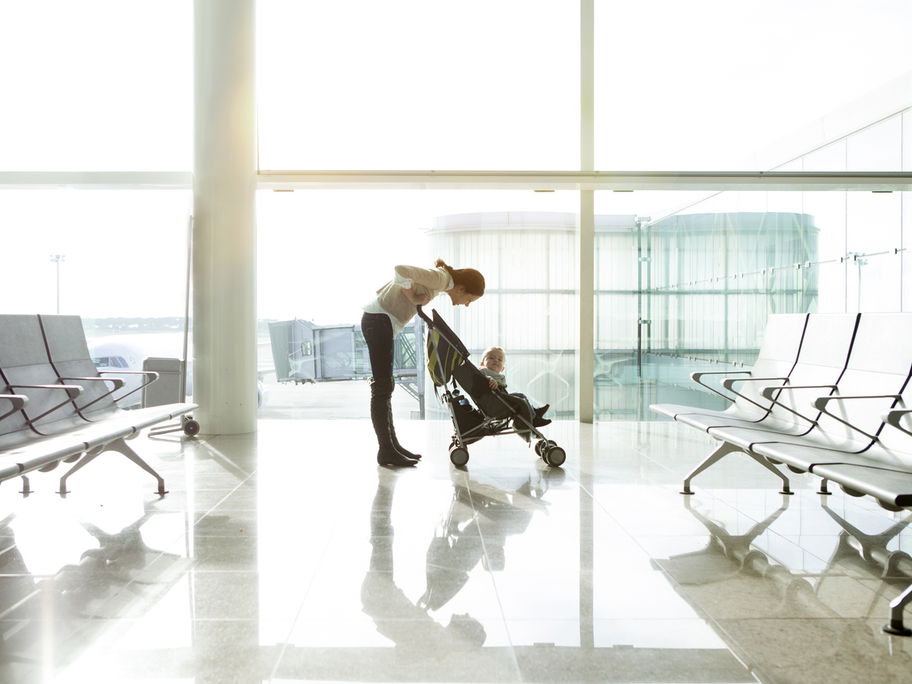 Mama mit Reisebuggy am Flughafen