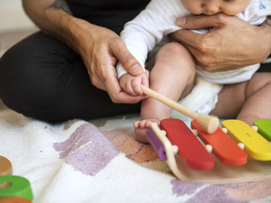Vater übt mit seinem Baby Xylophon-Spielen