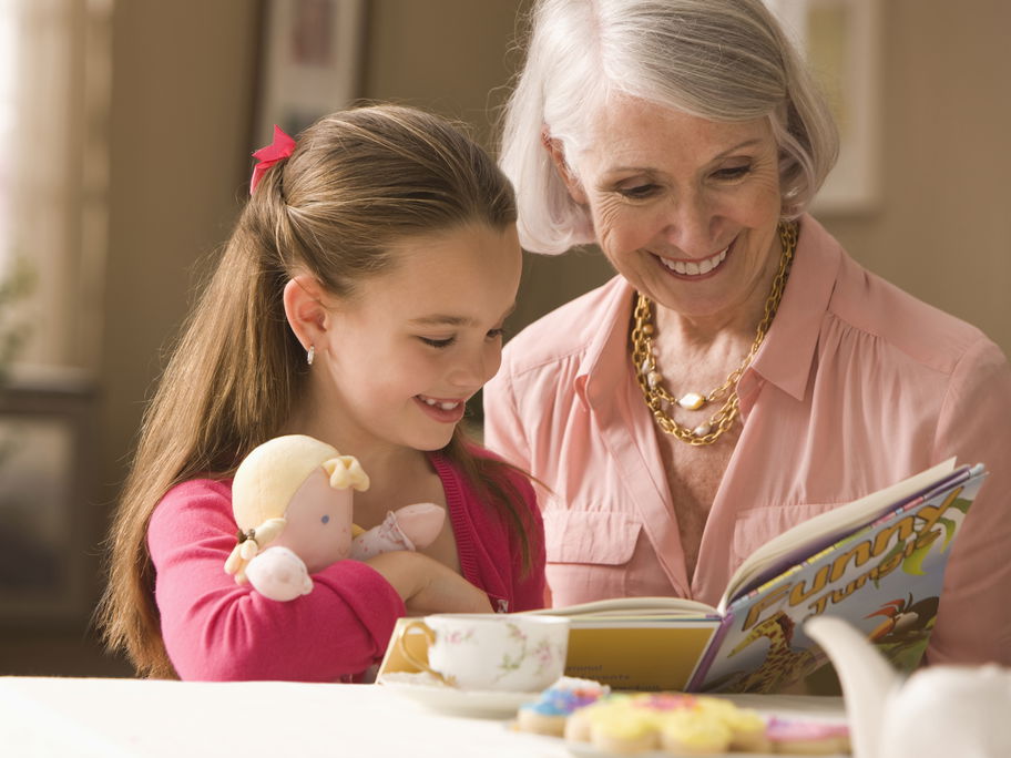 Oma schaut mit Enkelin ein Buch an.