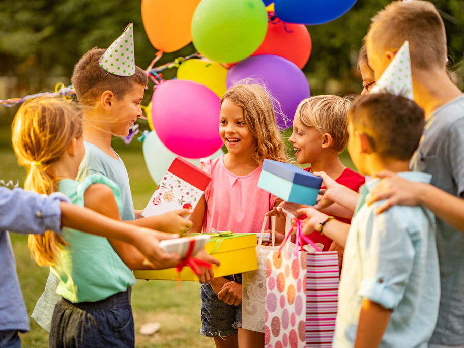 Kinder überreichen ihre Geschenke beim Kindergeburtstag