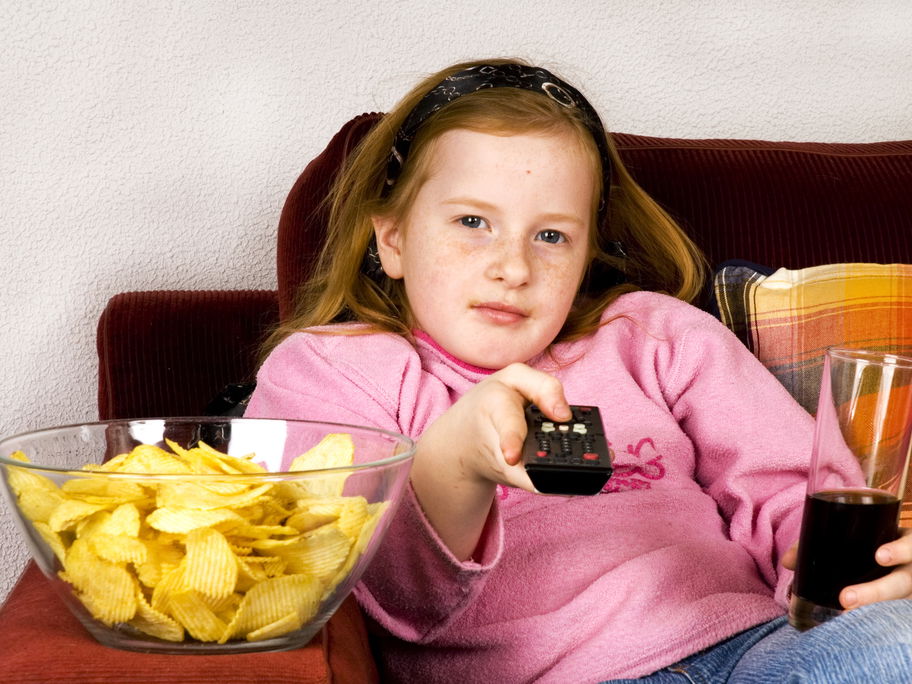 Mädchen mit Cola, Fernbedienung und Chips.