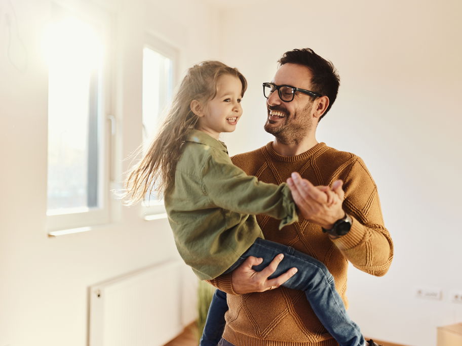 Lachender Vater trägt seine Tochter.