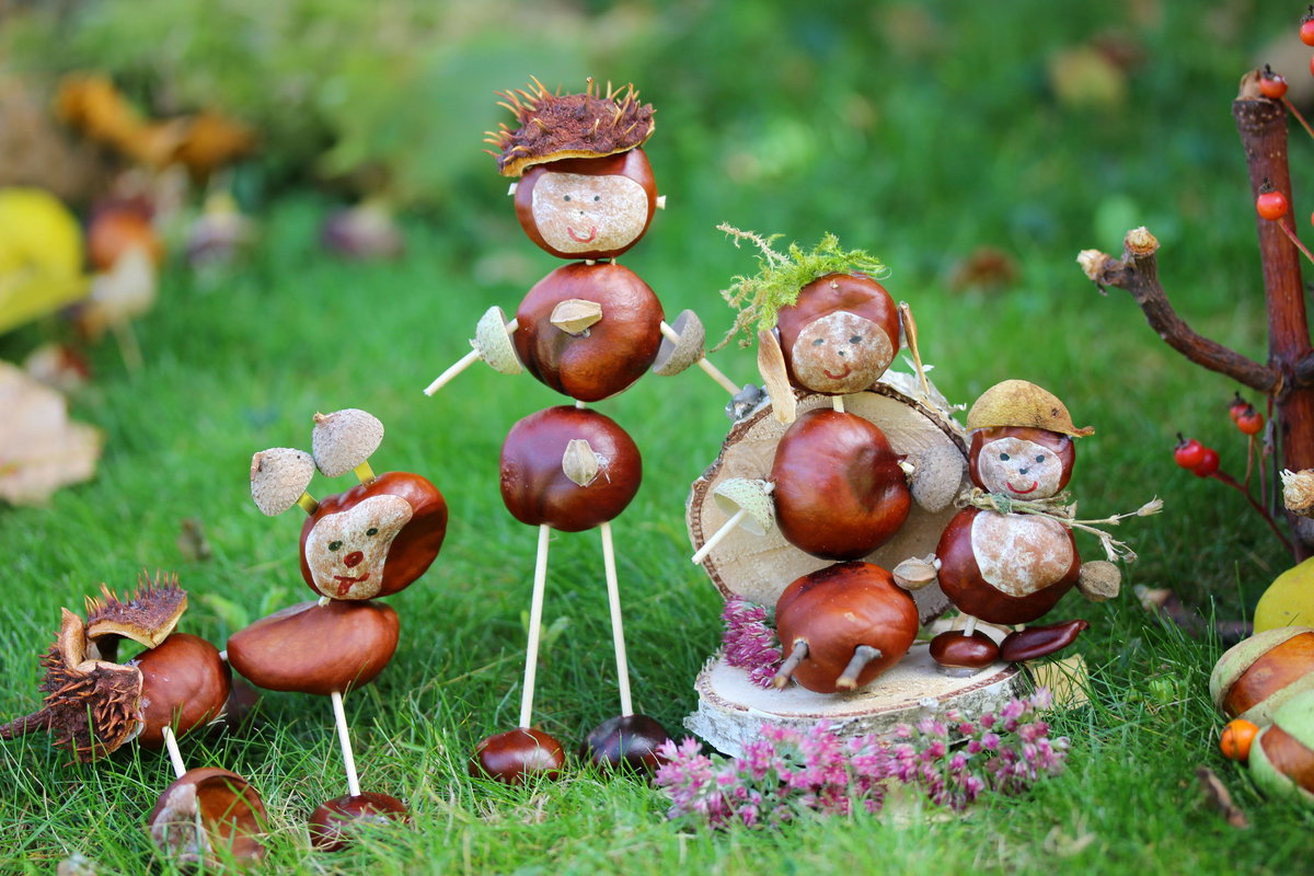 Süße Kastanienfiguren stehen im Garten.