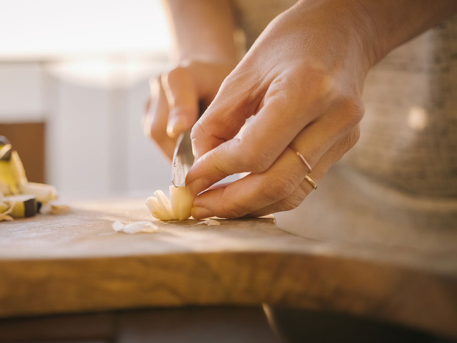 Eine Frau schneidet Knoblauch in Scheiben.