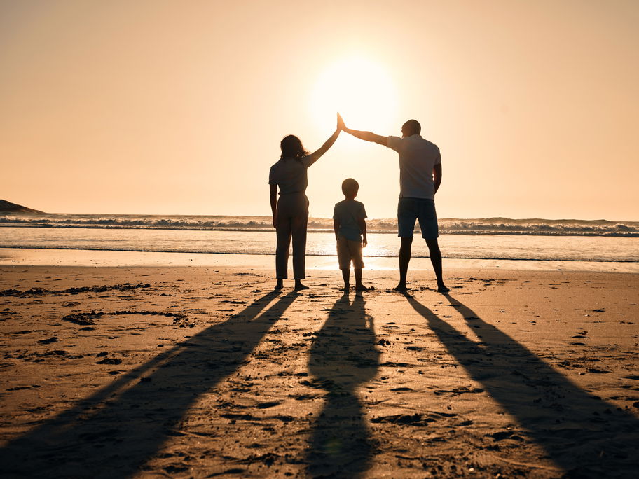 Familie am Strand im Sonnenuntergang.