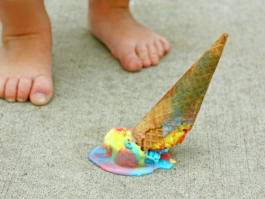 Nackte Kinderfüße, ein Eis liegt auf dem Boden