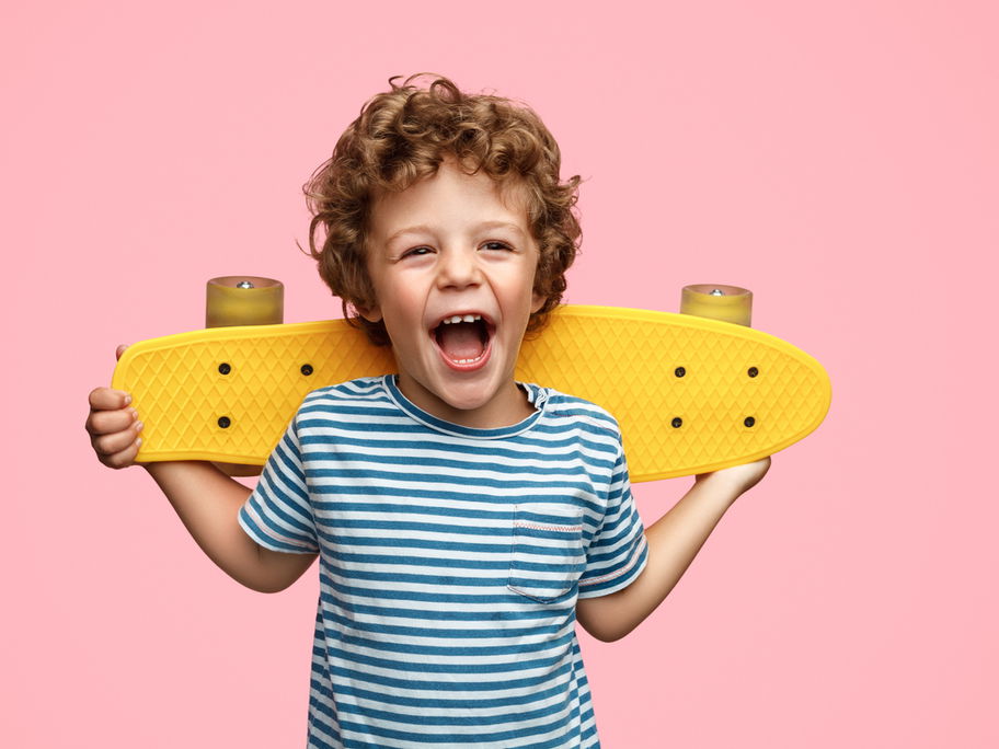 Niedlicher Junge mit gelbem Skateboard.