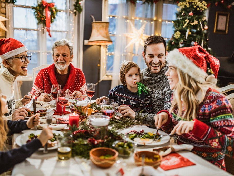 Familie sitzt Weihnachten zusammen am Tisch.