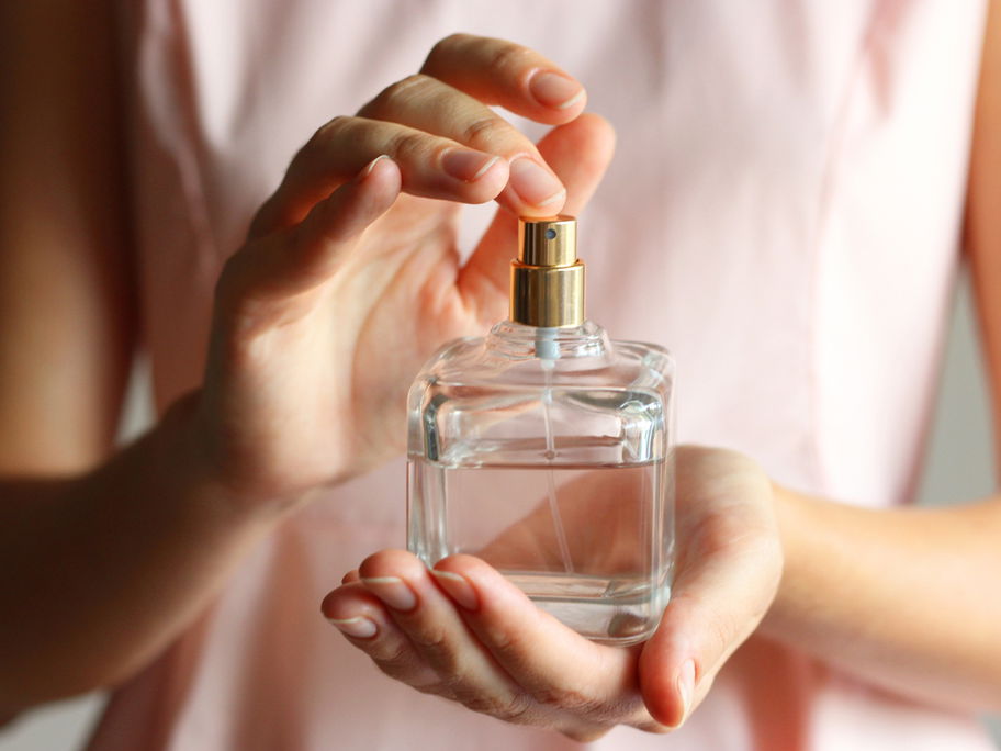 Eine Mutter hält eine Flasche Baby-Parfum in den Händen