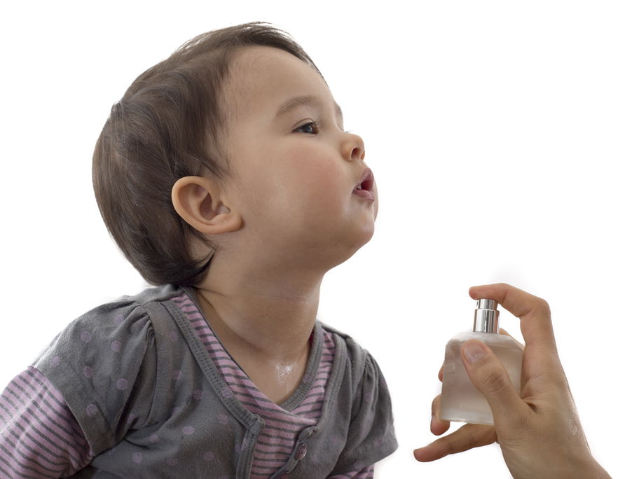 Baby wird mit einem Parfum eingesprüht.