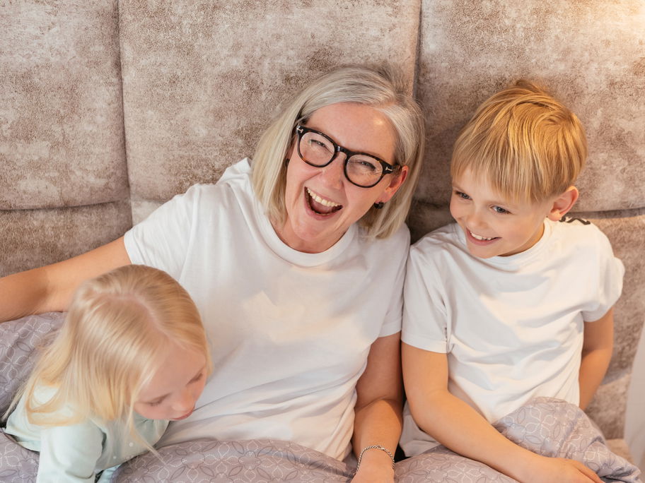 Oma lacht mit ihren beiden Enkeln.