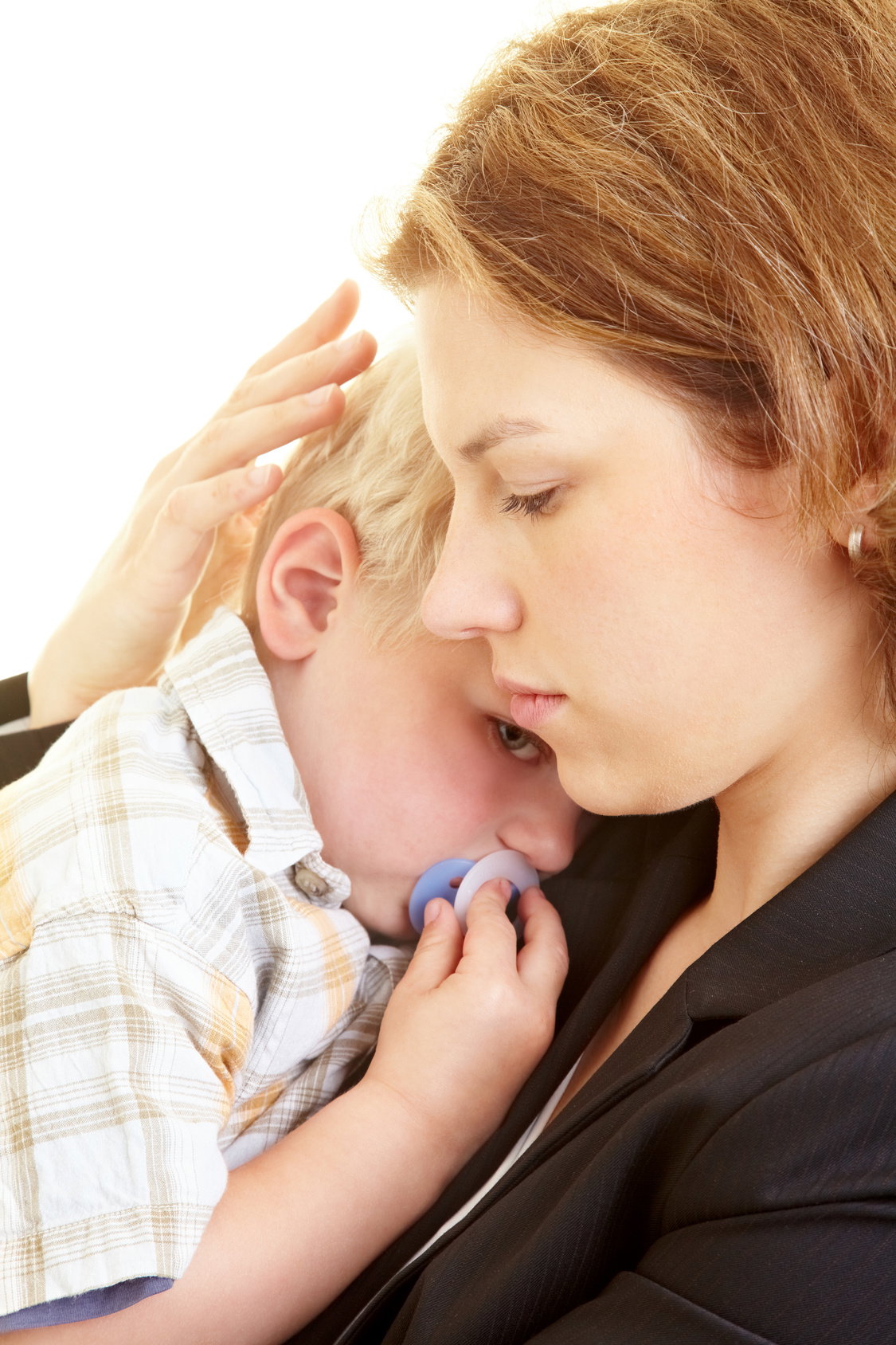 Ein trauriger Junge kuschelt sich an seine Mama.