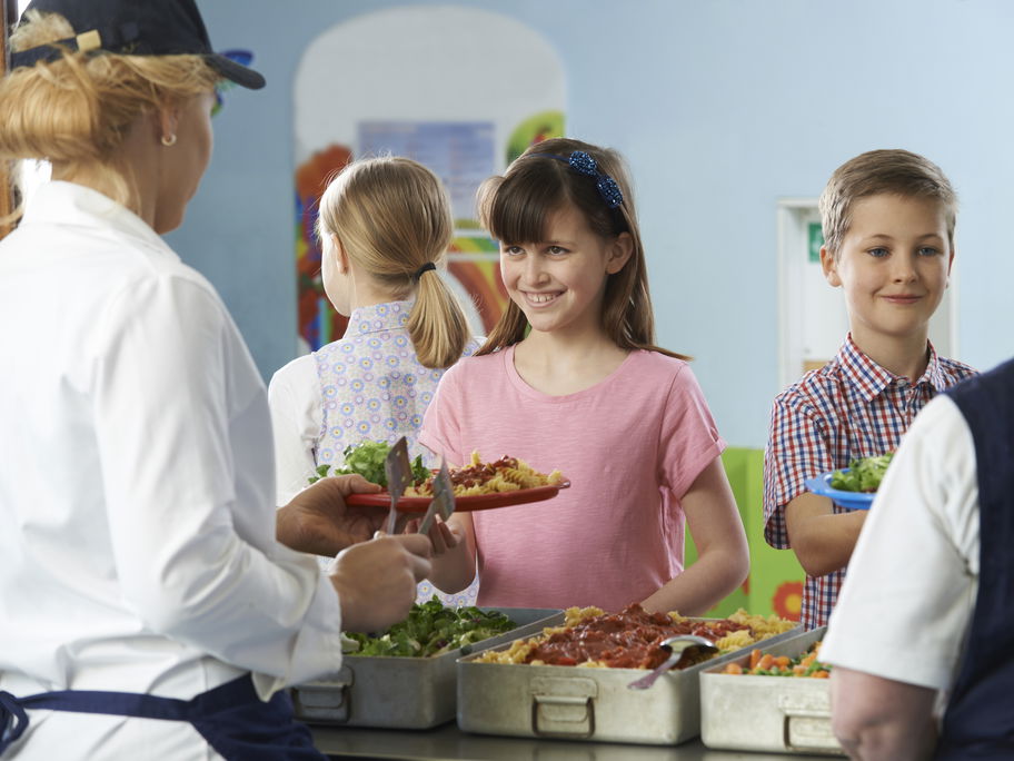 Kinder holen sich Essen in der Schulkantine.