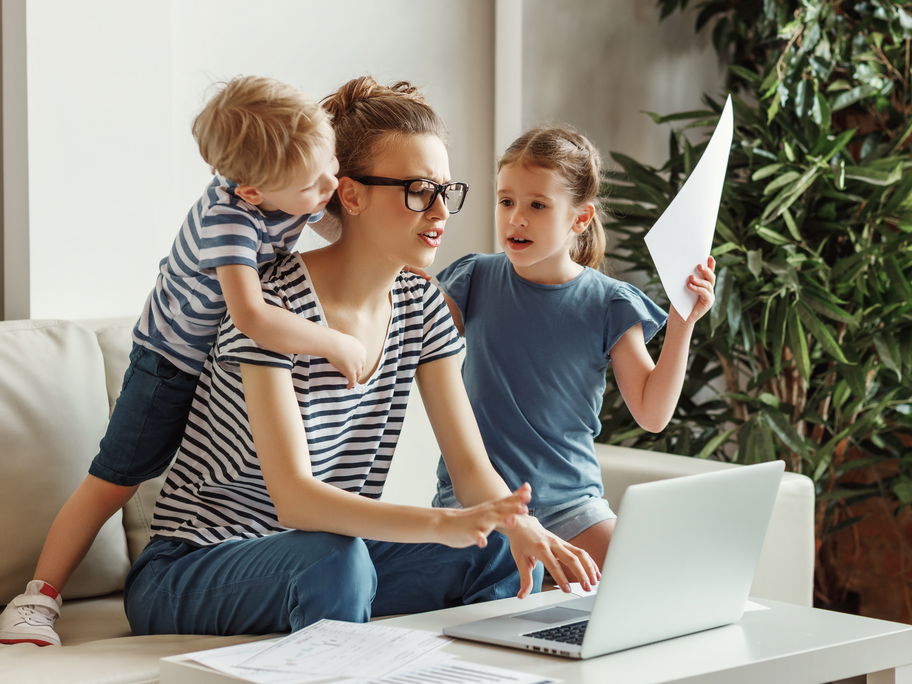 Frau am Laptop mit zwei Kindern.