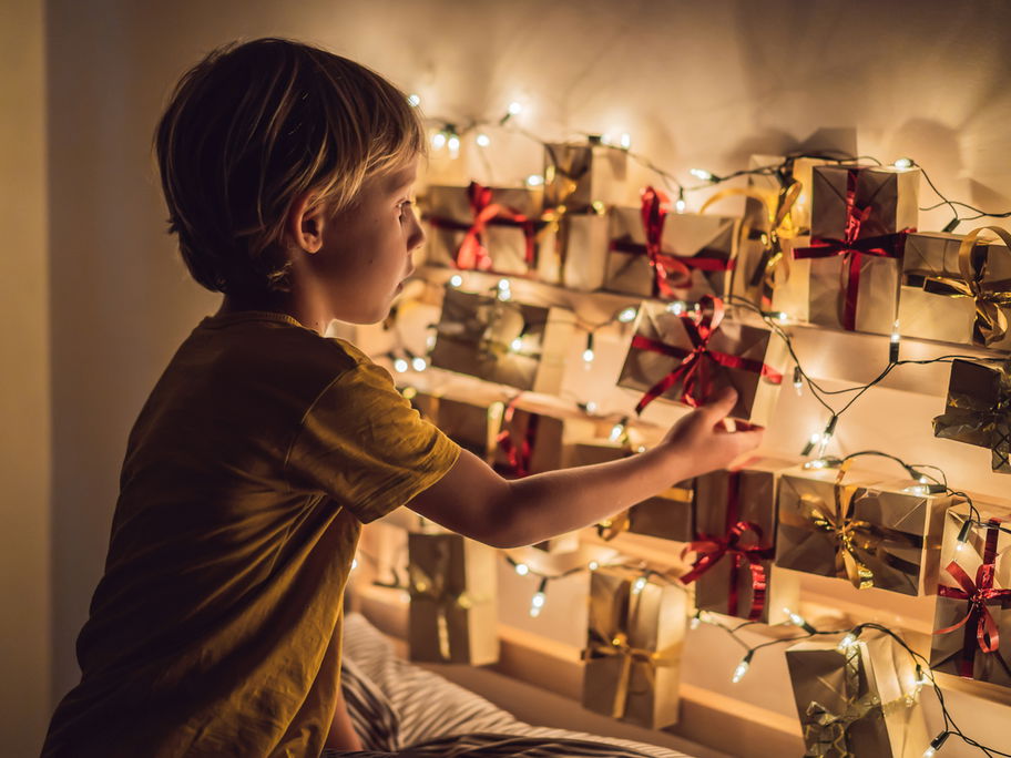 Ein kleiner Junge öffnet ein Türchen seines Adventskalenders.