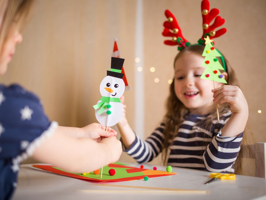 Zwei Kinder basteln Schneemänner