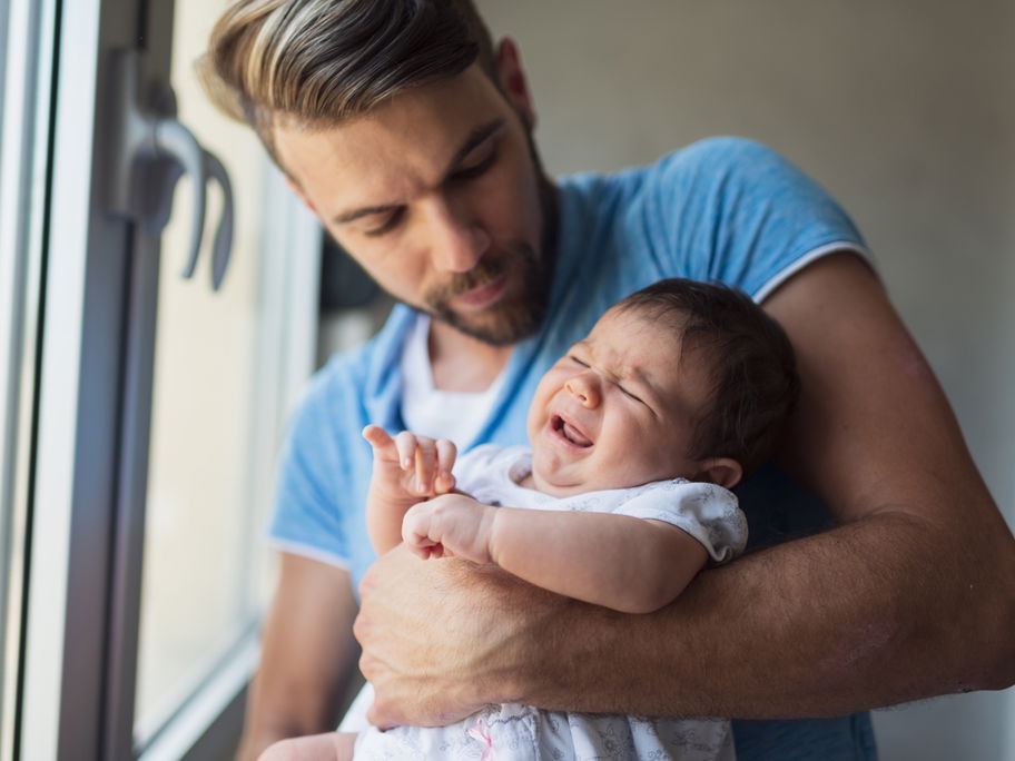 Junger Vater mit Baby auf dem Arm: Papas in Elternzeit müssen sich viele blöde Sprüche anhören.