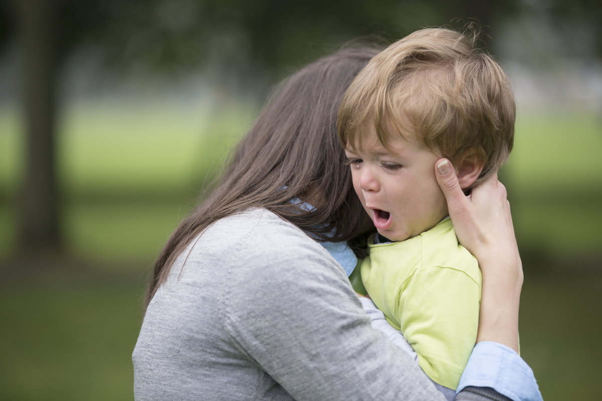Ein kleiner Junge wird bei einem Wutanfall von seiner Mutter getröstet.