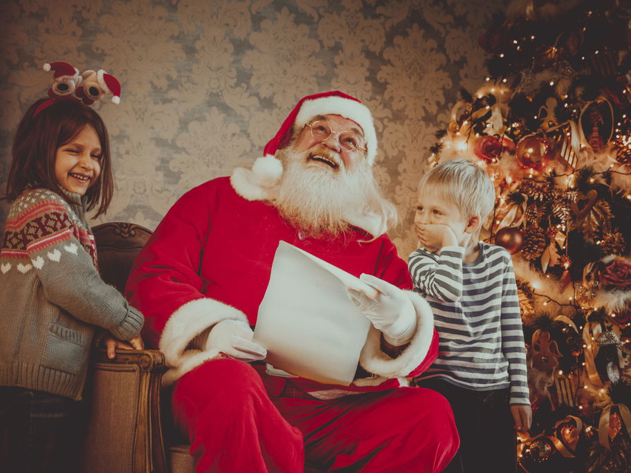 Nikolaus mit zwei Kindern lachen über einen lustigen Nikolausspruch.