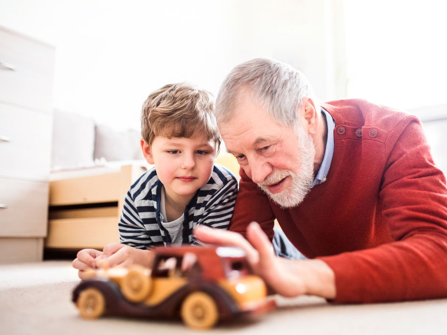 Großvater spielt mit seinem Enkel Auto.