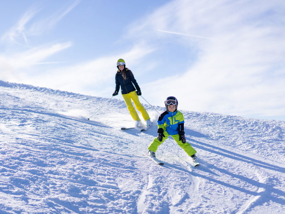 Eine Mutter bringt ihrem Sohn das Skifahren bei.