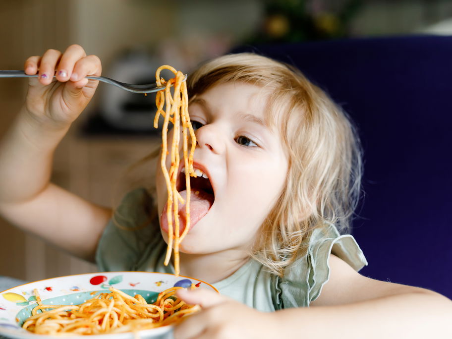 Kind isst Spaghetti.