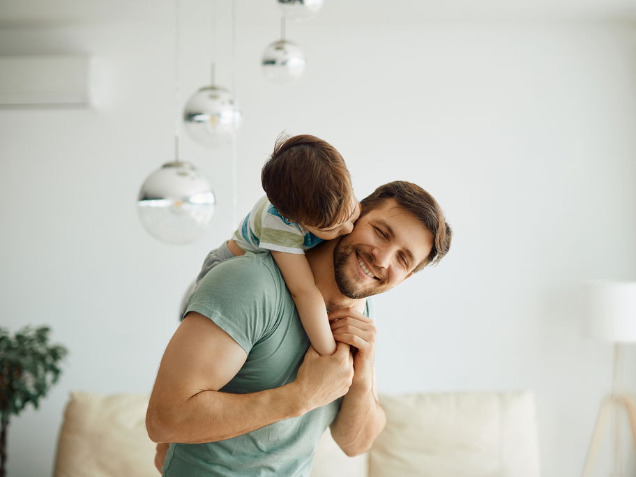 Vater trägt seinen Sohn auf dem Rücken.