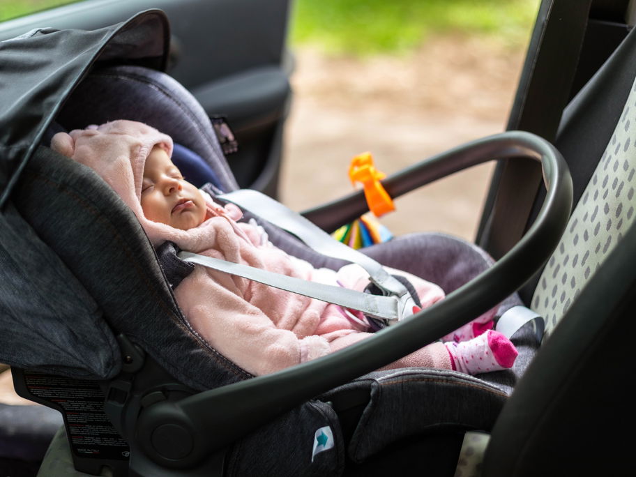 Ein Baby, das im Auto eingeschlafen ist.