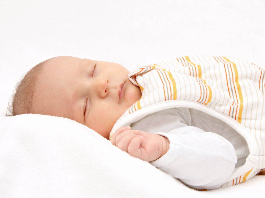 Ein Baby schläft im Winter im Schlafsack.