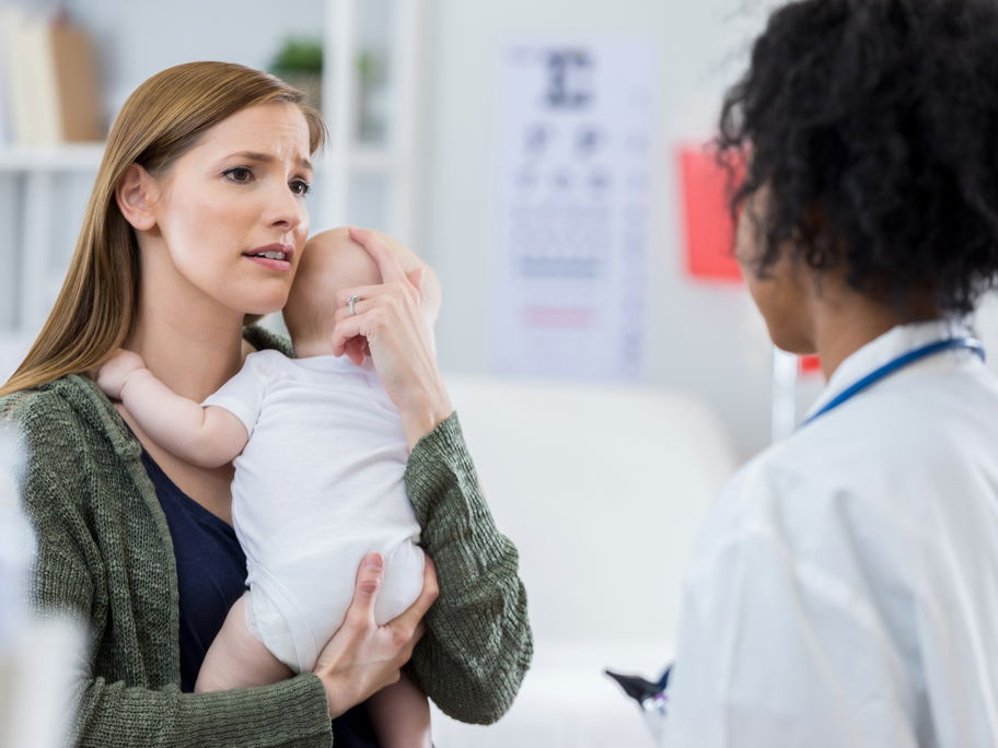 Eine Mutter steht mit ihrem Baby auf dem Arm in der Notfallambulanz.