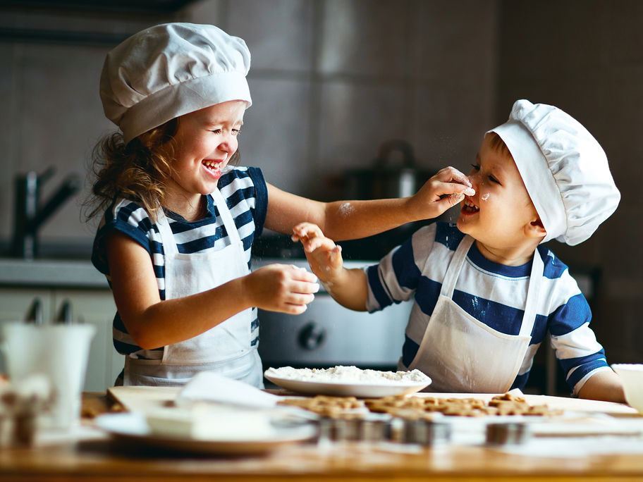 Zwei kleine, niedliche Kinder backen Kekse.