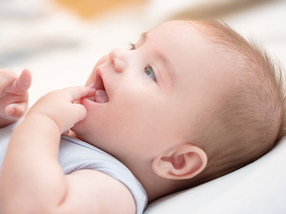 Baby saugt an seinem Finger – typisch für die orale Phase.