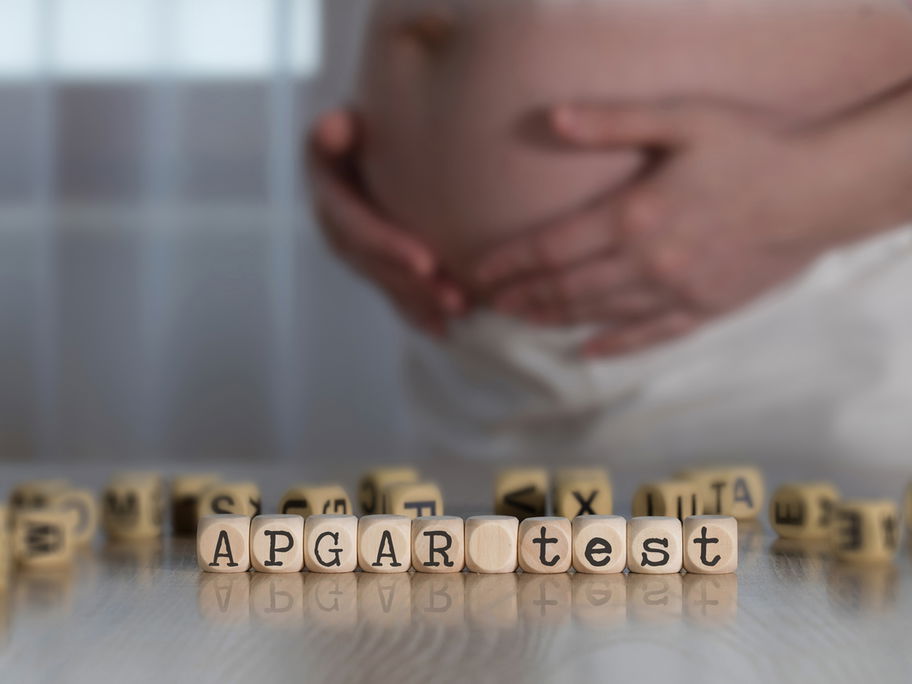 Schwangere Frau hinter dem Wort "Apgar-Test".