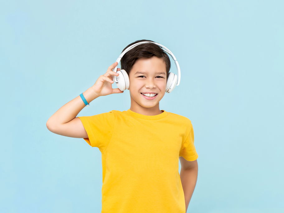 10-jähriger Junge hört Musik mit Headphones.