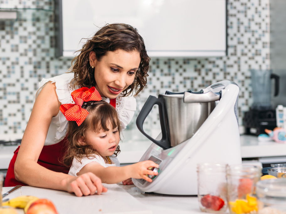Mutter und Tochter bedienen eine Küchenmaschine.