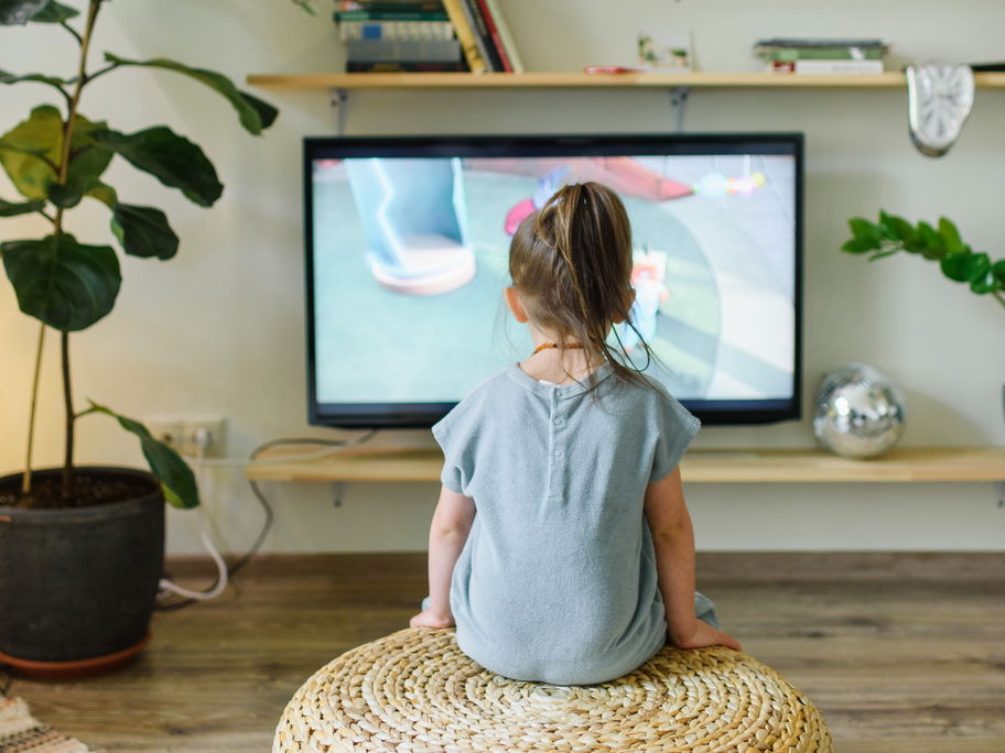 Ein kleines Mädchen guckt Fernsehen.