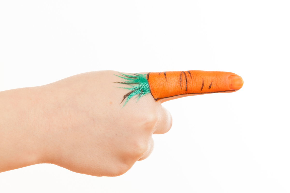 Ein Finger, auf den eine Möhre gemalt ist