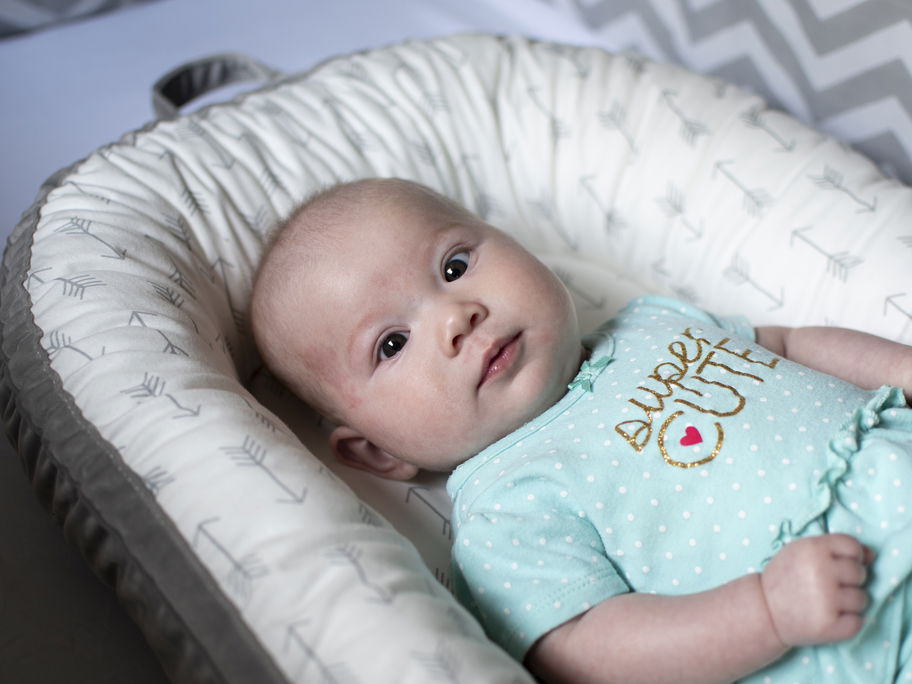 Baby liegt im Babynest.
