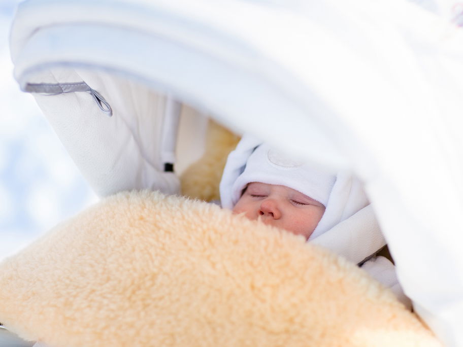 Baby schläft im Winter draußen im Kinderwagen.