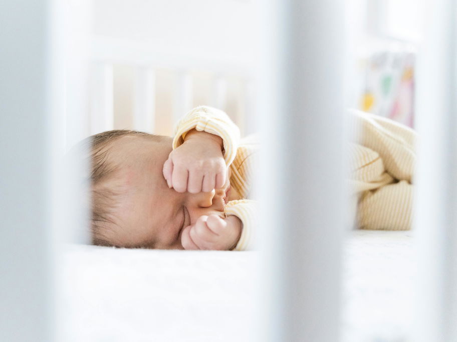 Ein kleines Baby schläft in seinem Bett.