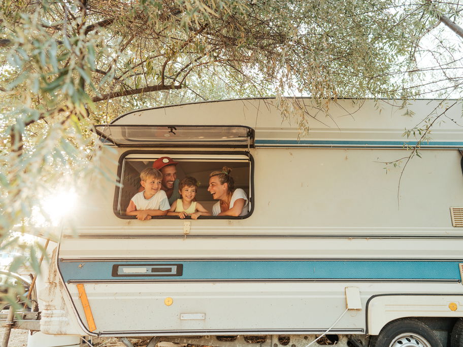 Familie schaut aus Wohnmobil-Fenster