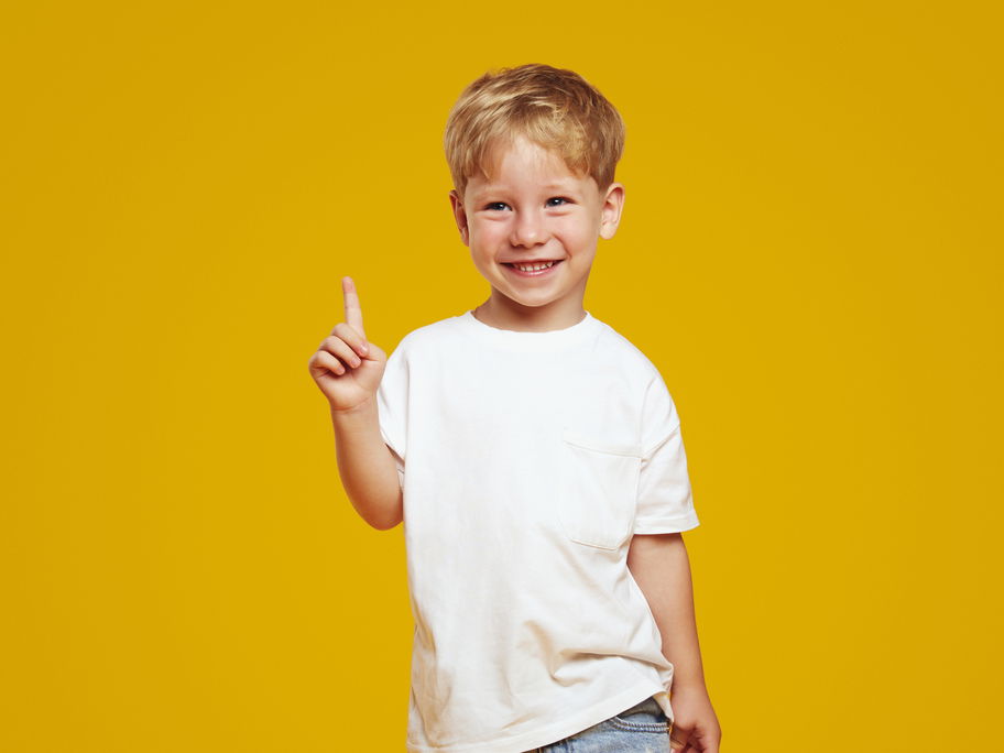 Ein kleiner Junge hebt seinen Zeigefinger