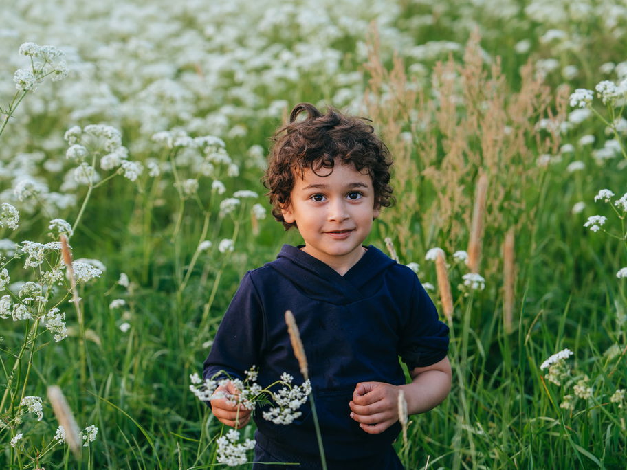 Ein kleiner Junge in einem Blumenfeld