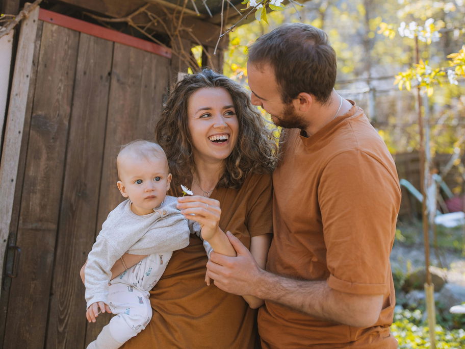 Glückliche Familie draußen mit Baby.
